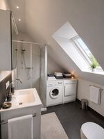 Modernes Duschbad mit Waschmaschine und Trockner Modernes Duschbad mit Waschmaschine und Trockner