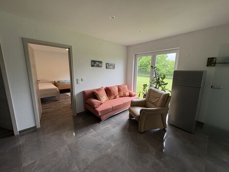 Wohnung 1: Wohnbereich mit Schlafcouch und Terrassentür Wohnung 1: Wohnbereich mit Schlafcouch und Terrassentür