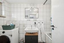 Bad mit Badewanne/Dusche und Waschtrockner Bad mit Badewanne/Dusche und Waschtrockner