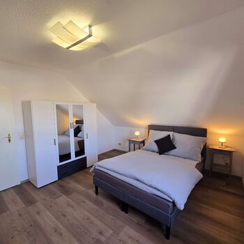 Geräumiges Schlafzimmer der Dachgeschosswohnung mit Doppelbett, Arbeitsplatz, Kleiderschrank und viel Platz. Geräumiges Schlafzimmer der Dachgeschosswohnung mit Doppelbett, Arbeitsplatz, Kleiderschrank und viel Platz.