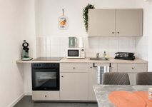 Die Küchenzeile in einem modernen Beige enthält einen Backofen inkl. Ceranfeld, eine Mikrowelle, ein Spülbecken, eine Kaffeemaschine, einen Wasserkocher, ein Abtropfgestell, Trockentücher und Platz zum Zubereiten von Speisen. Die Küchenzeile in einem modernen Beige enthält einen Backofen inkl. Ceranfeld, eine Mikrowelle, ein Spülbecken, eine Kaffeemaschine, einen Wasserkocher, ein Abtropfgestell, Trockentücher und Platz zum Zubereiten von Speisen.