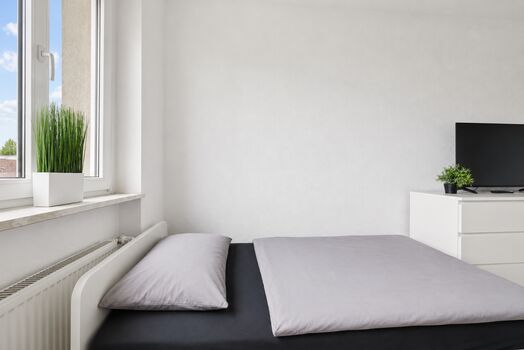 Schlafzimmer mit komfortablen Einzelbetten und Smart-TV für entspannte Abende. Schlafzimmer mit komfortablen Einzelbetten und Smart-TV für entspannte Abende.