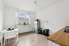 Voll ausgestattete Küche mit Spülmaschine, großem Kühlschrank und gemütlichem Sitzbereich. Voll ausgestattete Küche mit Spülmaschine, großem Kühlschrank und gemütlichem Sitzbereich.