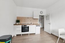 Voll ausgestattete Küche mit Spülmaschine, großem Kühlschrank und gemütlichem Sitzbereich. Voll ausgestattete Küche mit Spülmaschine, großem Kühlschrank und gemütlichem Sitzbereich.