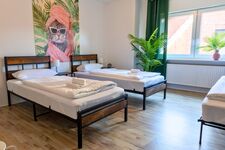 Schlafzimmer 1 mit drei Einzelbetten – flexibel kombinierbar, je nach Bedarf zusammengeschoben oder getrennt. Perfekt für Kollegen, die gemeinsam reisen. Schlafzimmer 1 mit drei Einzelbetten – flexibel kombinierbar, je nach Bedarf zusammengeschoben oder getrennt. Perfekt für Kollegen, die gemeinsam reisen.