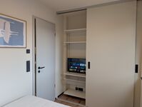 Schlafzimmer mit Schrank und Smart-TV Schlafzimmer mit Schrank und Smart-TV