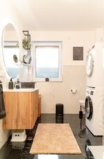 voll ausgestattetes Badezimmer mit Waschmaschine, Trockner und ebenerdiger Dusche voll ausgestattetes Badezimmer mit Waschmaschine, Trockner und ebenerdiger Dusche
