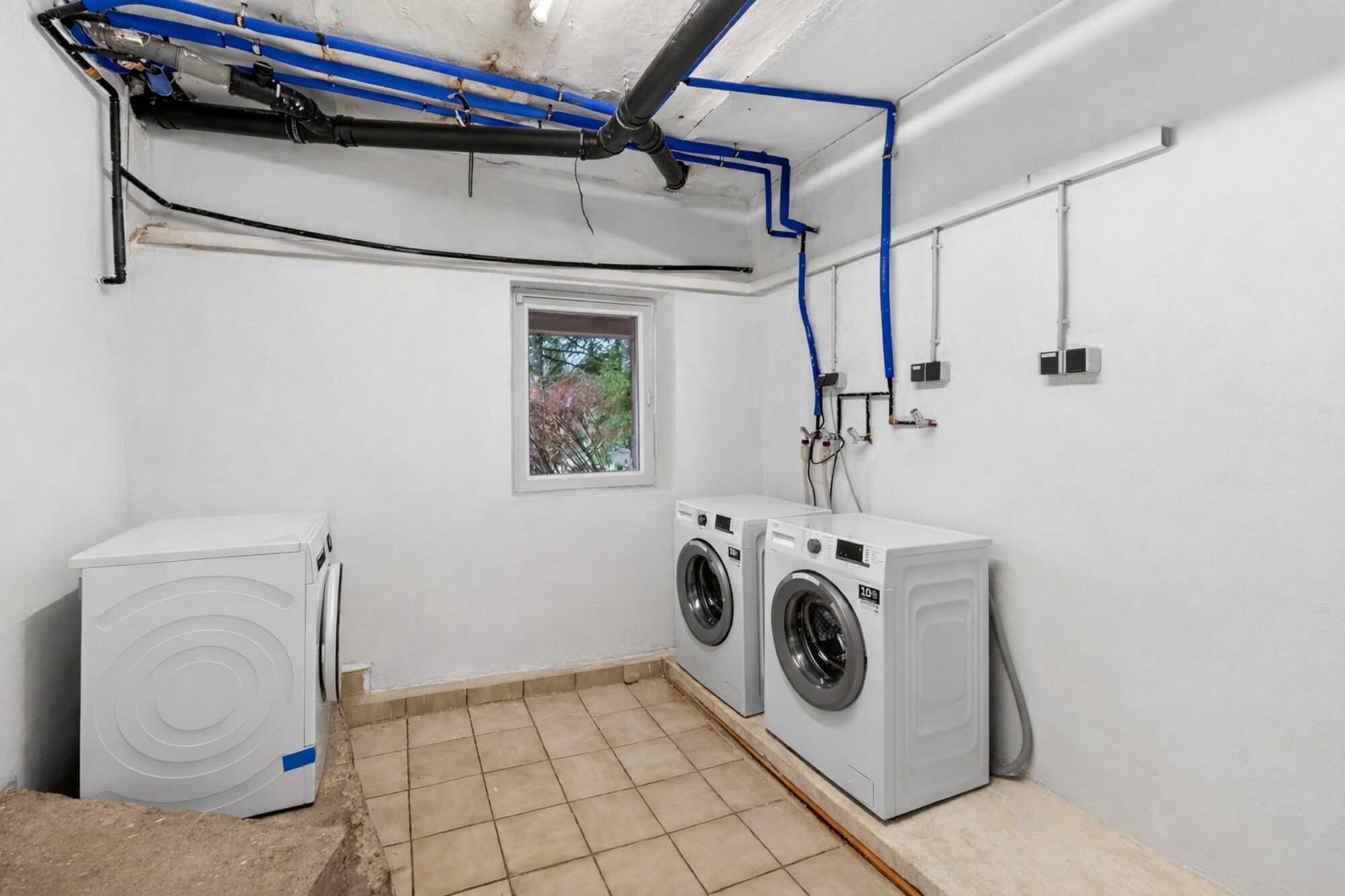 Waschraum im Keller mit Waschmaschine und Trockner – praktisch für längere Aufenthalte. Waschraum im Keller mit Waschmaschine und Trockner – praktisch für längere Aufenthalte.