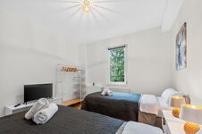 Wohnung 1: Schlafzimmer 2 mit hochwertigen Boxspringbetten, Nachttischen, offenem Kleiderschrank und Smart-TV. Die Betten können flexibel als Einzelbetten oder als komfortables Doppelbett gestellt werden. Wohnung 1: Schlafzimmer 2 mit hochwertigen Boxspringbetten, Nachttischen, offenem Kleiderschrank und Smart-TV. Die Betten können flexibel als Einzelbetten oder als komfortables Doppelbett gestellt werden.