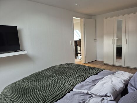 Schlafzimmer mit Doppelbett, TV und Kleiderschrank Schlafzimmer mit Doppelbett, TV und Kleiderschrank