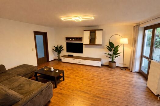 Wohnzimmer mit Flachbildschirm TV und Sofa mit Schlaffunktion Wohnzimmer mit Flachbildschirm TV und Sofa mit Schlaffunktion