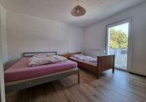 Schlafzimmer mit einem Ehebett und einem Einzelbett Schlafzimmer mit einem Ehebett und einem Einzelbett