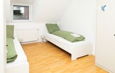 Schlafzimmer 2 mit zwei Einzelbetten, Sitzecke und Smart TV
