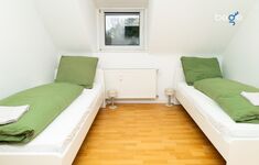 Schlafzimmer 2 mit zwei Einzelbetten, Sitzecke und Smart TV