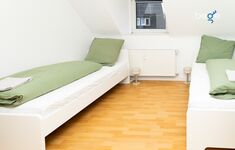 Schlafzimmer 2 mit zwei Einzelbetten, Sitzecke und Smart TV