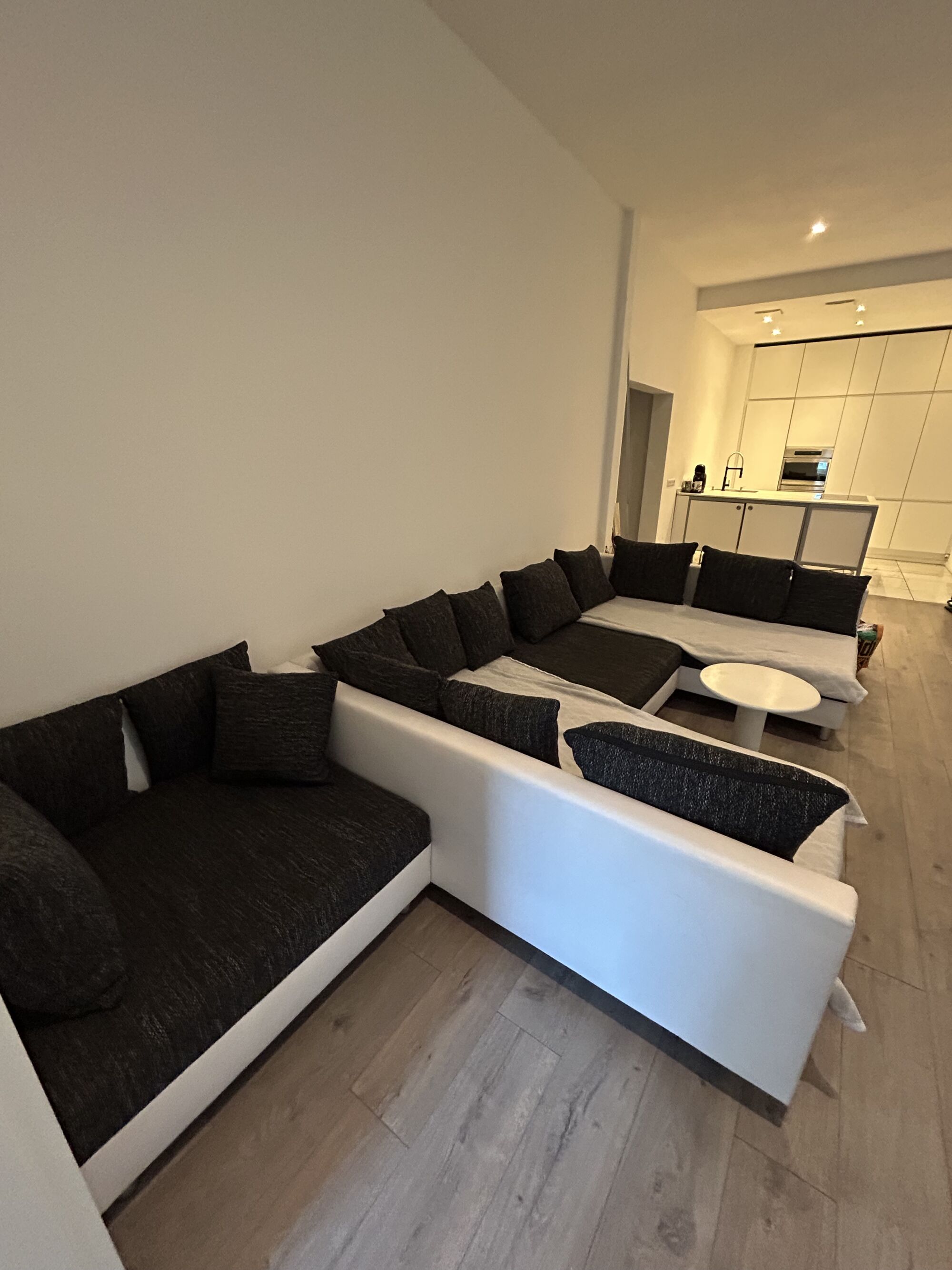 Modernes Wohnzimmer mit großem Sofa & 60-Zoll-TV – ideal zum Entspannen nach der Arbeit