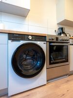 Küche mit Waschtrockner-Kombination, Spülmaschine, Herd (inkl. Pflanzenöl) mit Backofen, Kaffeemaschine (inkl. Kaffeepulver) und Wasserkocher (inkl. div. Teesorten)