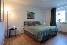Schlafzimmer 1 mit Doppelbett (optional), Stehlampe, Leselampe und privaten Steckdosen