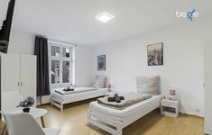 Schlafzimmer 1 mit zwei Einzelbetten, Sitzecke und Smart TV