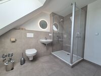 Das helle, einladende Bad lädt dazu ein, sich in entspannter Atmosphäre frisch zu machen. / The bright, inviting bathroom invites you to freshen up in a relaxed atmosphere.