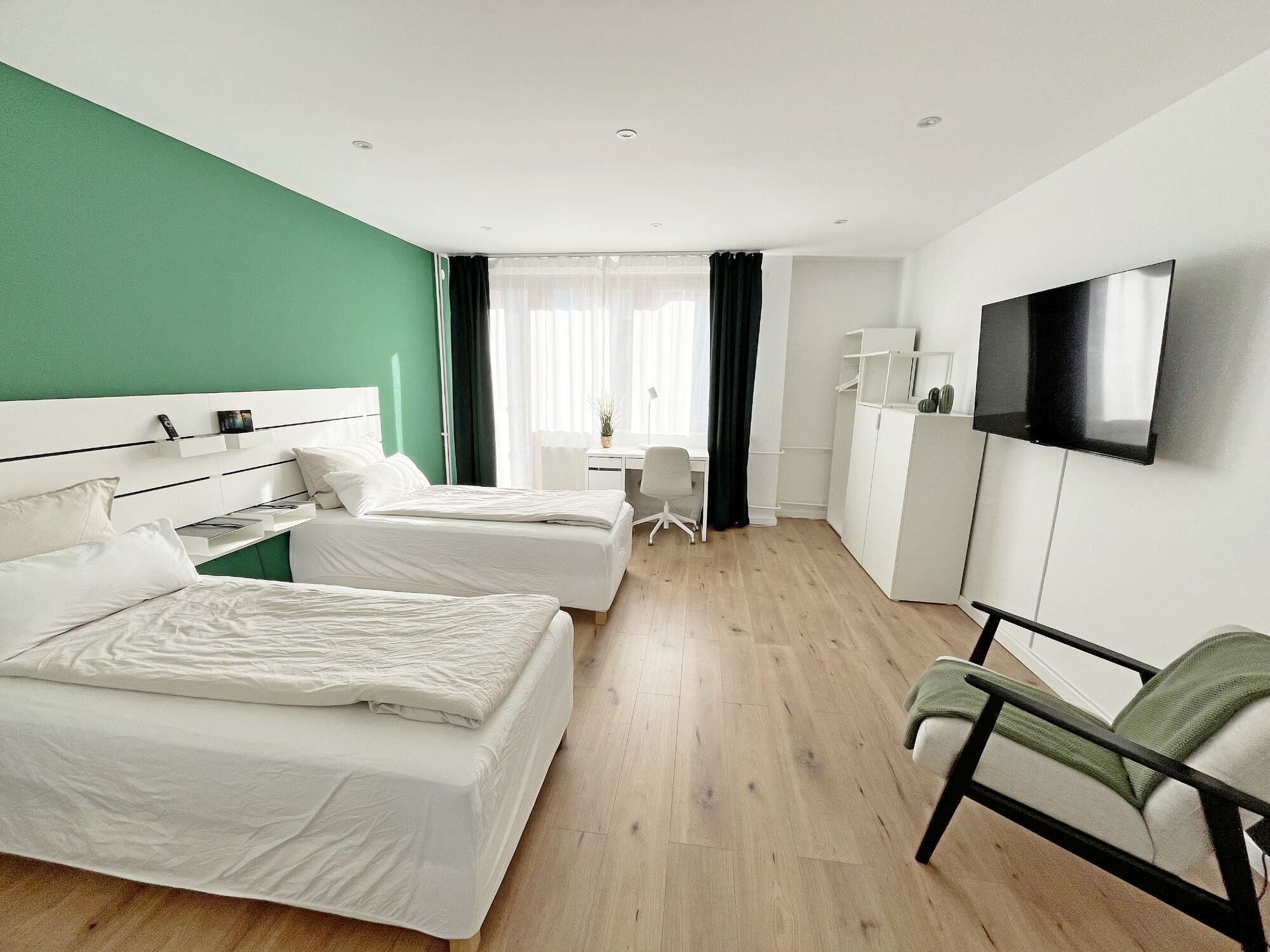 An jedem Bett ist ein Handyladekabel und zusätzlich eine Handyladestation an der Schreibtischleuchte, 90x200 Betten und ein warmes Zimmer mit 50 Zoll Smart TV Fernseher.