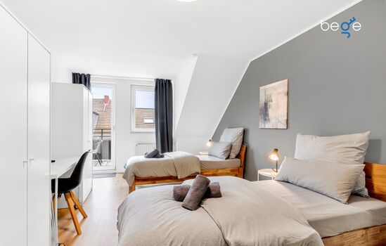 Schlafzimmer 1 mit zwei Einzelbetten, Sitzecke und Smart-TV