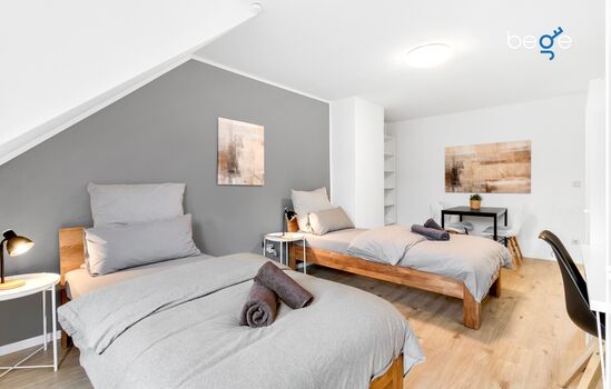 Schlafzimmer 1 mit zwei Einzelbetten, Sitzecke und Smart-TV