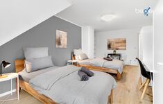 Schlafzimmer 1 mit zwei Einzelbetten, Sitzecke und Smart-TV