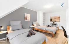 Schlafzimmer 1 mit zwei Einzelbetten, Sitzecke und Smart-TV