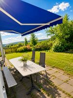 großer Gartentisch mit Schirm 