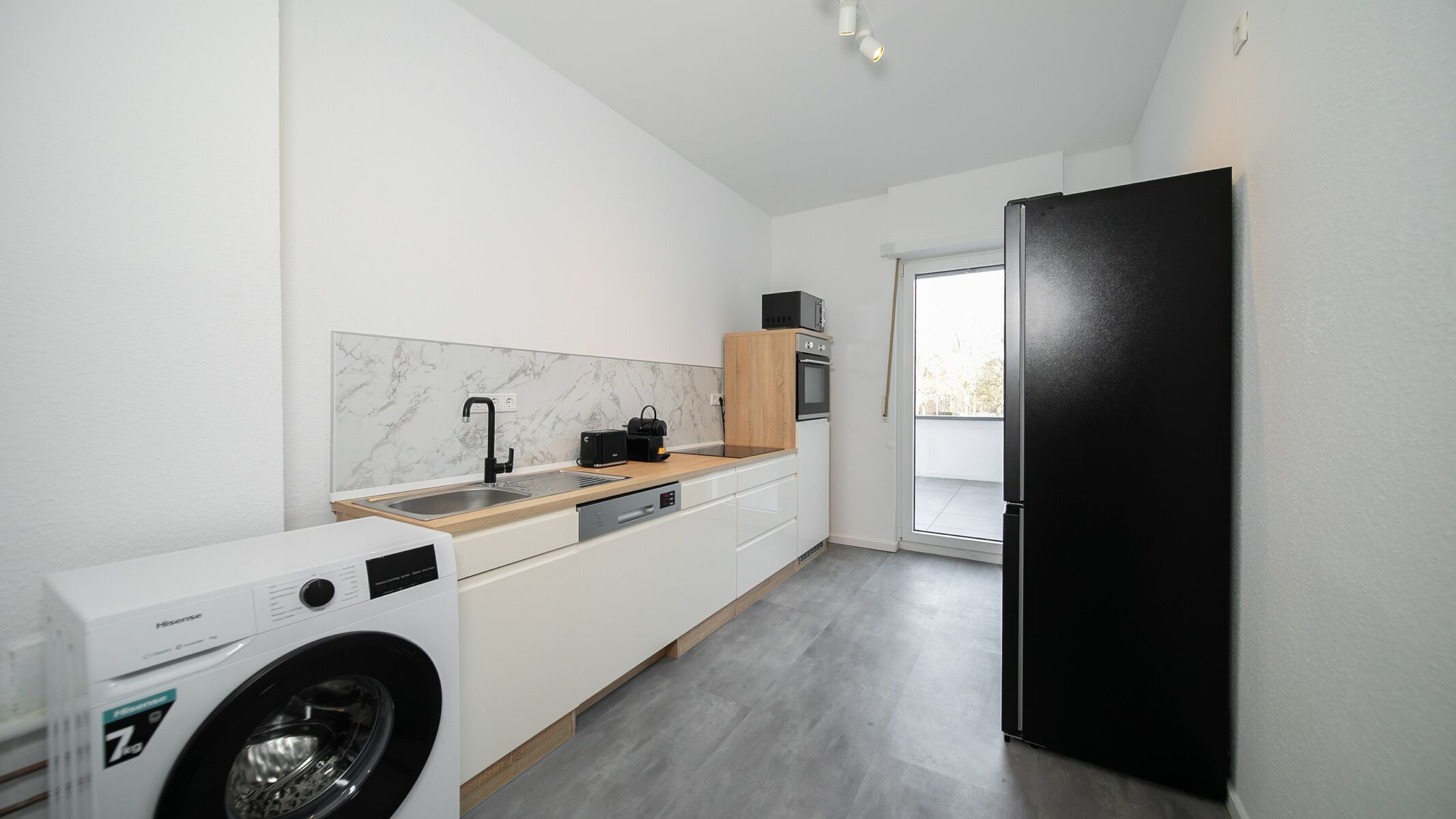 Küche mit Geschirrspüler, Waschmaschine und großen Kühlschrank