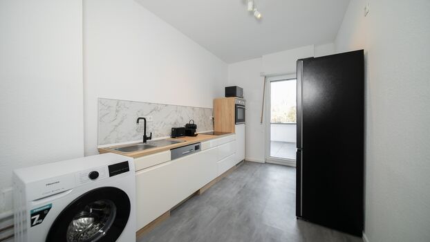 Küche mit Geschirrspüler, Waschmaschine und großen Kühlschrank