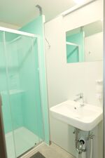 Eine von vier Duschkabinen mit Waschbecken, Garderobe & Spiegel