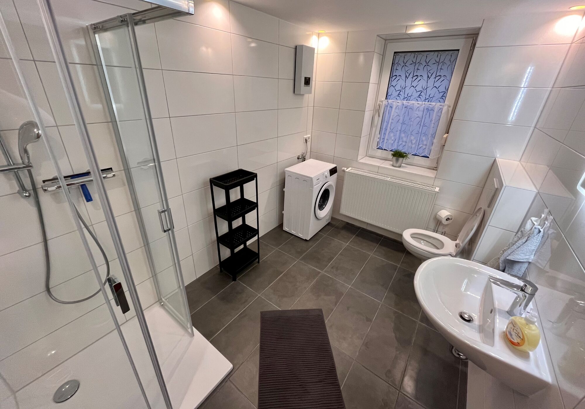 Frisch saniertes Wohlfühlbad mit eigener Waschmaschine – Sauberkeit und Komfort für Ihr Team, wie zu Hause