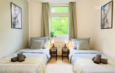 Schlafzimmer 1 mit zwei Einzelbetten, Sitzecke und Smart TV 