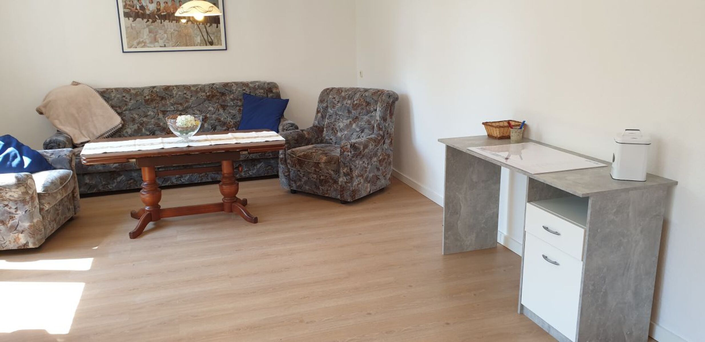 Großes Wohnzimmer mit Schreibtisch, Sofaecke und Fernseher 