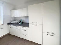 Der Kühlschrank in der Einbauküche bietet ein Gefrierfach für Tiefkühlspeisen.