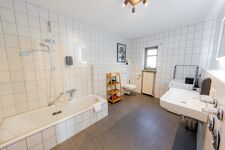 Badezimmer mit Badewanne und Duschtrennwand
