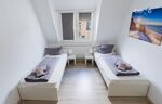 Schlafzimmer 2 mit zwei Einzelbetten, Sitzecke und Smart TV 