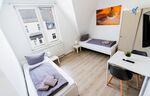 Schlafzimmer 1 mit zwei Einzelbetten, Sitzecke und Smart TV 