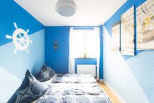 Gemütliches Sofa unter dem Fenster lädt zum Lesen oder Ausruhen ein – perfekte Ergänzung zum Schlafbereich. #ApartmentDuisburg #bequemwohnen #SofaRelax #lichtdurchflutet #Wohlfühlraum #DuisburgZimmer #komfortfürgäste #praktischesDesign