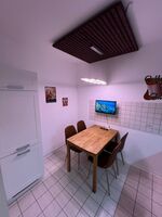 Gut ausgestattete Küche mit großem Kühlschrank und Smart-TV