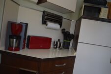 Toaster, Kaffeemaschine und Mikrowelle auf dem Kühschrank