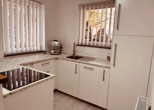 Neuwertige, voll ausgestattete Küche mit Backofen, Kühlschrank mit Tiefkühlfach, Dampfgarer, Toaster und umfangreichen Koch- und Küchenutensilien.