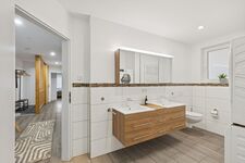 Bad mit Doppelwaschbereich und Blick in den Flur