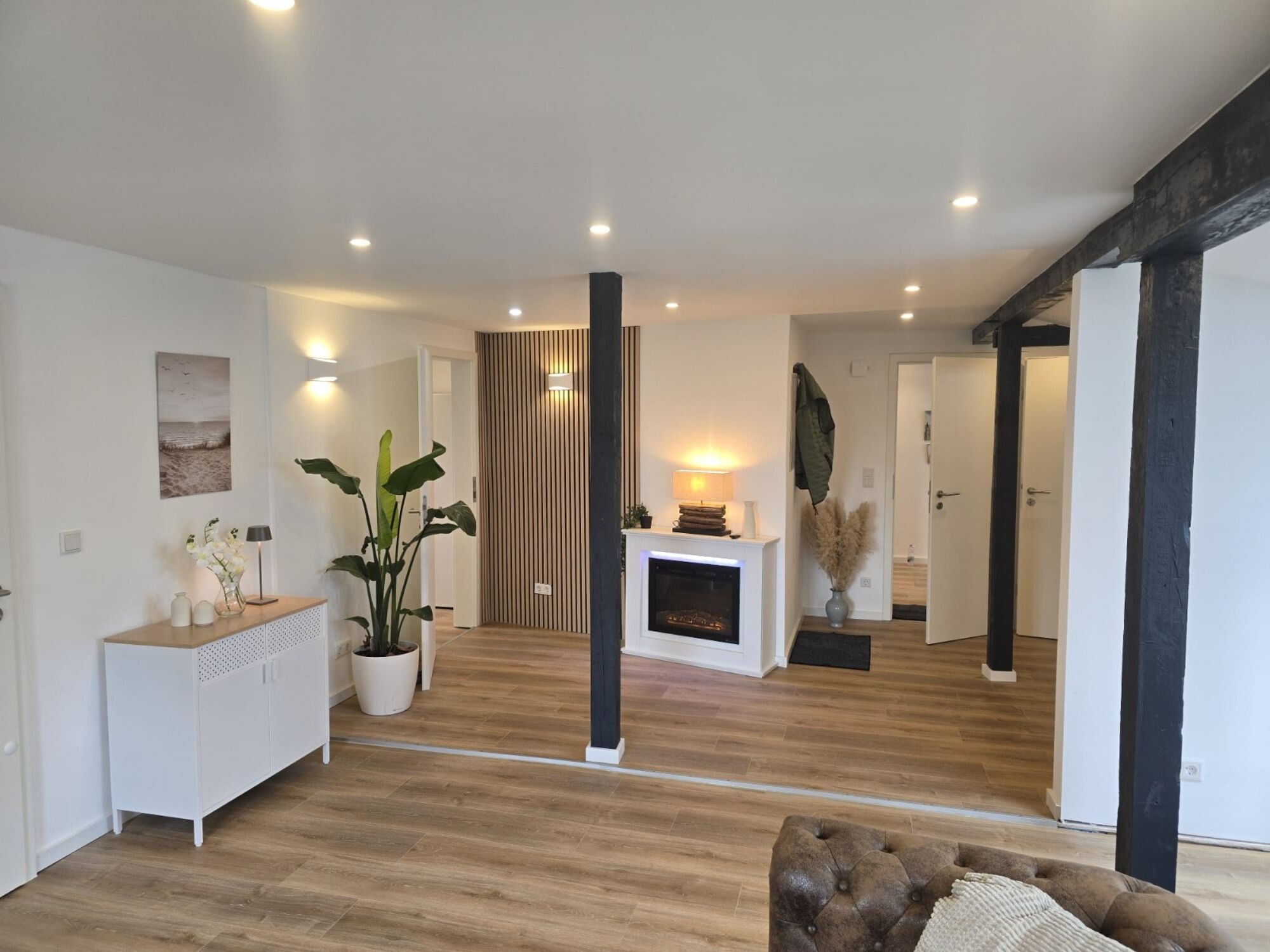 Gemütliches Wohnzimmer mit Bett, TV, Kleiderschrank & elektrischem Kamin