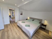 Gemütliches Schlafzimmer mit Bett, TV & Kleiderschrank