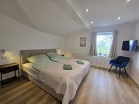 Gemütliches Schlafzimmer mit Bett, TV & Kleiderschrank