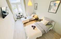 Schlafzimmer 1 mit zwei Einzelbetten, Sitzecke und Smart TV 