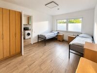 Helles Zimmer mit getrennten Betten, Schrank und Zugang zur Küche